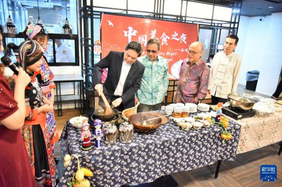8月23日,在文莱首都斯里巴加湾市的拉克萨马纳商学院,嘉宾在“中国美食之夜——品味广西”活动上体验广西炒茶。新华社记者 李萌 摄