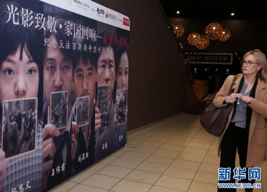 8月8日,一名观众观看澳大利亚悉尼一电影院内放置的《南京照相馆》海报。记者 马平 摄