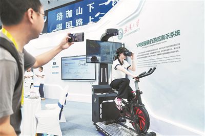 2025世界数字教育大会上,学生正在展示武汉大学研发的VR校园骑行游览展示系统。 中新社记者 张祥毅摄